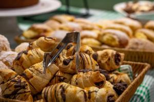 a bunch of pastries in baskets on a table at Pousada Iguassu Charm Suites in Foz do Iguaçu