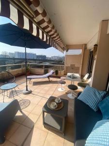 ein Wohnzimmer mit einem Sofa, Tischen und einem Sonnenschirm in der Unterkunft Havre de paix Dax in Dax