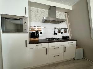 uma cozinha com armários brancos e um forno com placa de fogão em New modern apartment (55m2) in the city center em Enschede