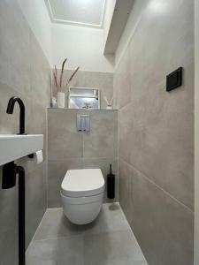 uma casa de banho com um WC branco e um lavatório. em New modern apartment (55m2) in the city center em Enschede