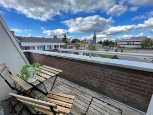 um pátio com 2 cadeiras e uma mesa no telhado em New modern apartment (55m2) in the city center em Enschede