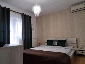 a bedroom with a large bed and a chandelier at Relax Apartament in Constanţa