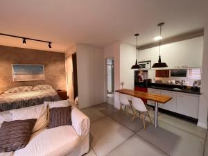 Flat Itaim في ساو باولو: غرفة نوم بسرير وطاولة ومطبخ