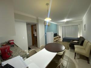 a kitchen and living room with a table and a couch at Apart no Águas da Serra - 115B in Rio Quente