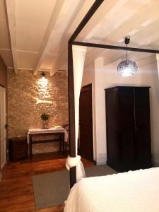 ein Schlafzimmer mit einem Bett und einem Tisch in einem Zimmer in der Unterkunft Passiflore au Mas d'Escampette in Soupex