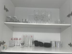 a shelf with wine glasses and plates on it at Panorama 901 in Oradea