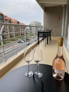 butelkę wina i dwa kieliszki na stole w obiekcie Petit plage Nieuwpoort-Bad w mieście Nieuwpoort