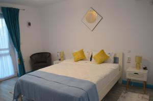 - une chambre avec un grand lit et des oreillers jaunes dans l'établissement Agropensiune Caban, à Jurilovca