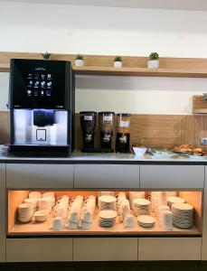 a kitchen with plates and a microwave on a shelf at Hotel Albergaria Borges in Chaves