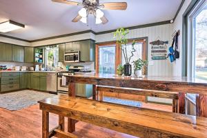 eine Küche mit einem Holztisch und einem Deckenventilator in der Unterkunft Lakefront Hartland Cottage with Patio and Fire Pits! in Hartland