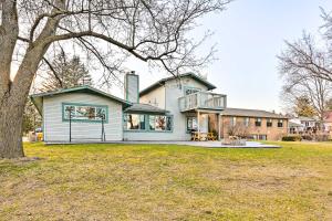 a house with a large yard in front of it at Lakefront Hartland Cottage with Patio and Fire Pits! in Hartland