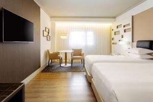 pokój hotelowy z łóżkiem, stołem i krzesłami w obiekcie Madrid Marriott Auditorium Hotel & Conference Center w Madrycie