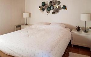 1 dormitorio con 1 cama blanca y 2 mesitas de noche con lámparas en Awesome Home In Ijhorst With Kitchen, en IJhorst