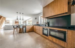 una cocina con armarios de madera y electrodomésticos negros en Cozy Home In Blancafort With Heated Swimming Pool, 