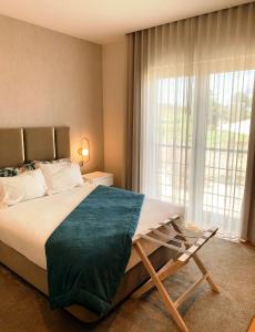a bedroom with a large bed and a large window at Hotel Albergaria Borges in Chaves