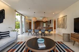 uma sala de estar com um sofá e uma mesa em 308-303 Beautiful apartments with 3 bedrooms em Tulum