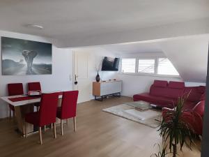 a living room with a red couch and a table at Apartma FRIGO in Maribor