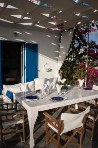 a white table and chairs on a patio at Arcana Santorini Villas, An Authentic Cycladic Experience in Akrotiri
