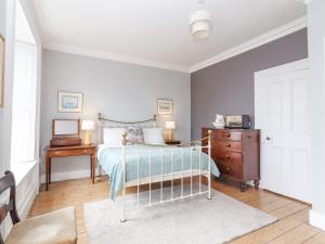 een slaapkamer met een bed met een dressoir en een nachtkastje bij The Merchant's House in Kilrush