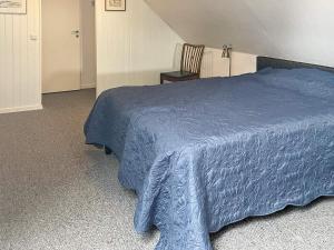 ein Schlafzimmer mit einem blauen Bett und einem Stuhl in der Unterkunft Holiday home SJÖBO in Vollsjö