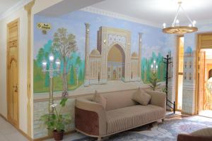 a living room with a couch and a mural on the wall at Sultanat Hotel in Samarkand