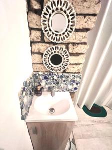 a bathroom with a sink and a stone wall at Casa artistica CANDELARIA in Bogotá