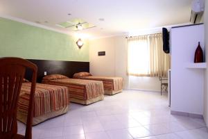 a hotel room with two beds and a television at Monte Serrat Hotel in Santos