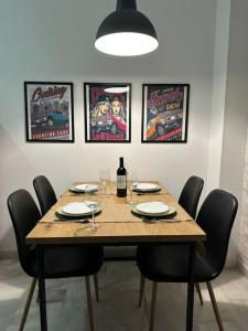 una mesa de madera con sillas y una botella de vino en Moderno apartamento junto al mar- Apartamentos Don Diego, en Torremolinos