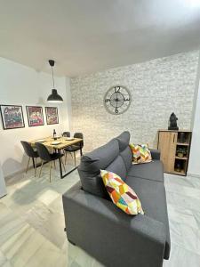 sala de estar con sofá y comedor en Moderno apartamento junto al mar- Apartamentos Don Diego, en Torremolinos
