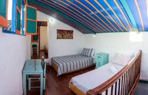 Habitación con 2 camas, mesa y cama sidx sidx sidx sidx en Misiá Emilia, Café - Hostal en Apía