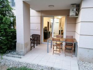 un patio con mesa y sillas. en Zamárdi apartman, en Zamárdi