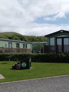a house with a sign in the grass at Adorable Caravan in Western Lakes in Workington