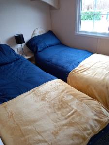 two beds sitting next to each other in a bedroom at Adorable Caravan in Western Lakes in Workington