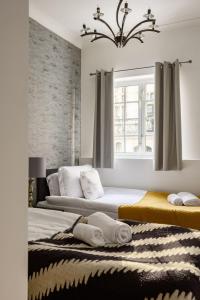 1 Schlafzimmer mit 2 Betten und einem Kronleuchter in der Unterkunft Park Street Mayfair apartments in London