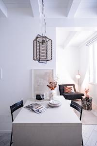 a white dining room with a white table and chairs at HYGGE APT - FERRARA CENTRO in Ferrara