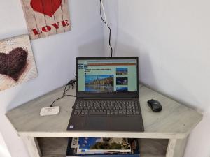 um computador portátil sentado numa mesa com um rato em Le Palmaro em Menton