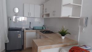 a kitchen with white cabinets and a counter top at Chicama D'Amore - Family Place & Wave Paradise - Parking & kidszone - on Puerto Chicama in Puerto Chicama +5 photos