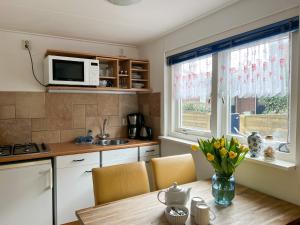 Vakantiewoning aan Zee - 150m van het Strand في إغموند آن زي: مطبخ مع طاولة عليها مزهرية من الزهور +23 صورة