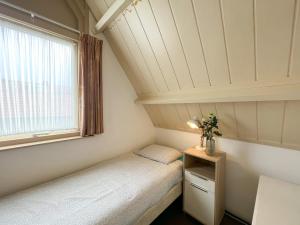 Vakantiewoning aan Zee - 150m van het Strand في إغموند آن زي: غرفة صغيرة بها سريرين ونافذة