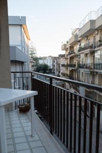 einen Balkon mit einem Tisch und einige Gebäude in der Unterkunft Mufasa B&B in Soverato Marina