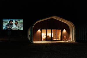 een gebouw met een groot scherm in het donker bij Frontier Drive Inn in Center