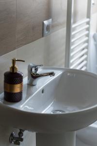 un lavandino in bagno con dispenser di sapone di Mufasa B&B a Soverato Marina