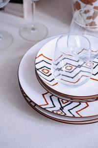 a white plate with two glasses on a table at HYGGE APT - FERRARA CENTRO in Ferrara +11 photos