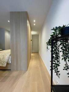 a hallway of a bedroom with a bed and a plant at Studio KZ modern studio in Knokke-Heist