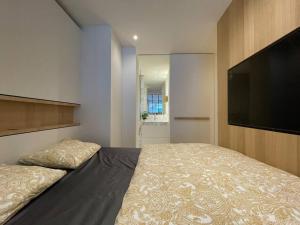 a bedroom with a bed and a flat screen tv at Studio KZ modern studio in Knokke-Heist