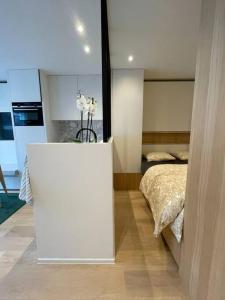 a bedroom with a bed and a white table in it at Studio KZ modern studio in Knokke-Heist