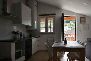 una cucina e una sala da pranzo con tavolo e sedie di Refúgio Transmontano a Bragança