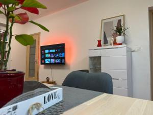 ein Wohnzimmer mit Fernseher und Tisch in der Unterkunft Split apartment - 5 min by car to the beach & city center - free public parking in Split