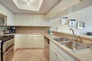 - une cuisine avec des placards blancs et un évier dans l'établissement Land's End 1-301 Gulf View - Premier, à St. Pete Beach