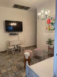 een woonkamer met een tv en een tafel en stoelen bij Departamento Ocre con gran jardín in San Isidro